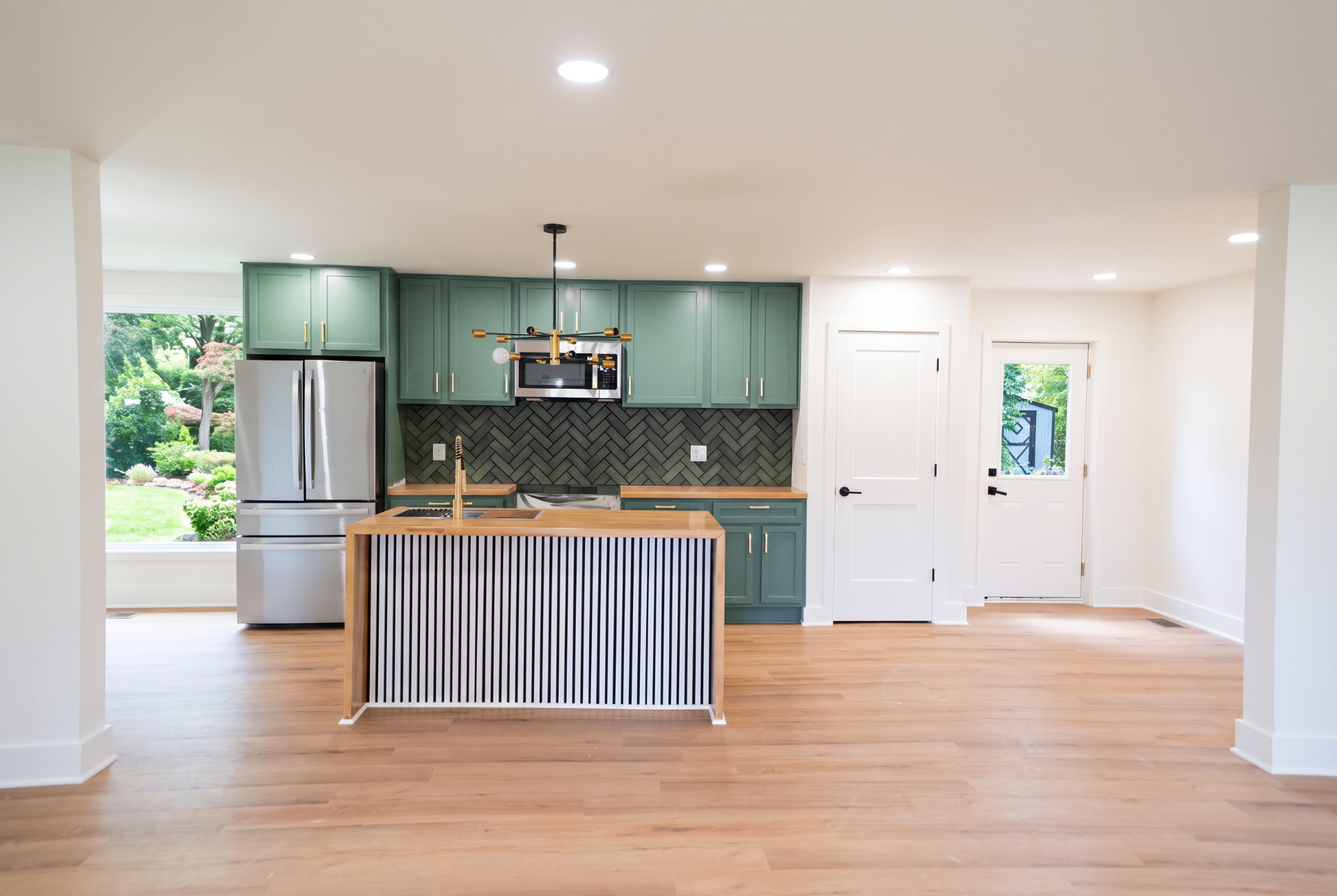 Modern kitchen with island, walnut cabinetry, and sage accents