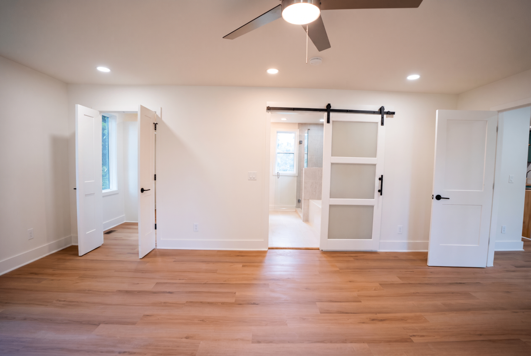 Primary bedroom with barn-door entry to the spa bath